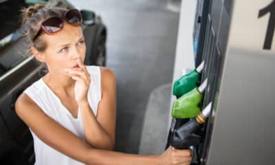 mulher com duvidas na bomba de gasolina