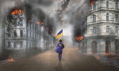 Imagem mostra menino carregando bandeira da Ucrânia.