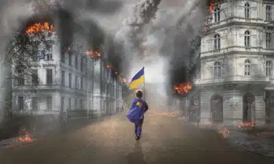 Imagem mostra menino carregando bandeira da Ucrânia.