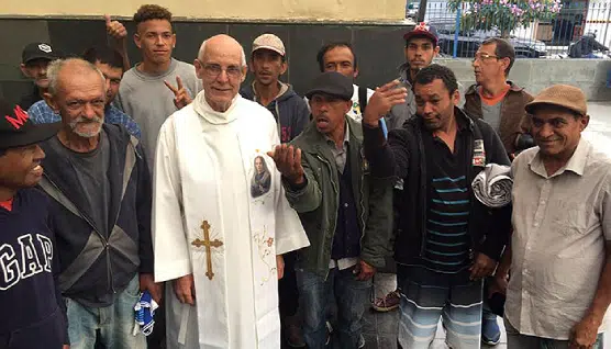 Imagem mostra o padre Julio Lancelloti entre pessoas do bairro; foto Sindicato dos Metalúrgicos.