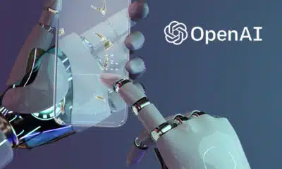 Imagem mostra mãos de robô manipulando um celular transparente.