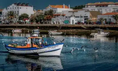 Imagem mostra um barco navegando por um canal de Tavira, no Algarve.